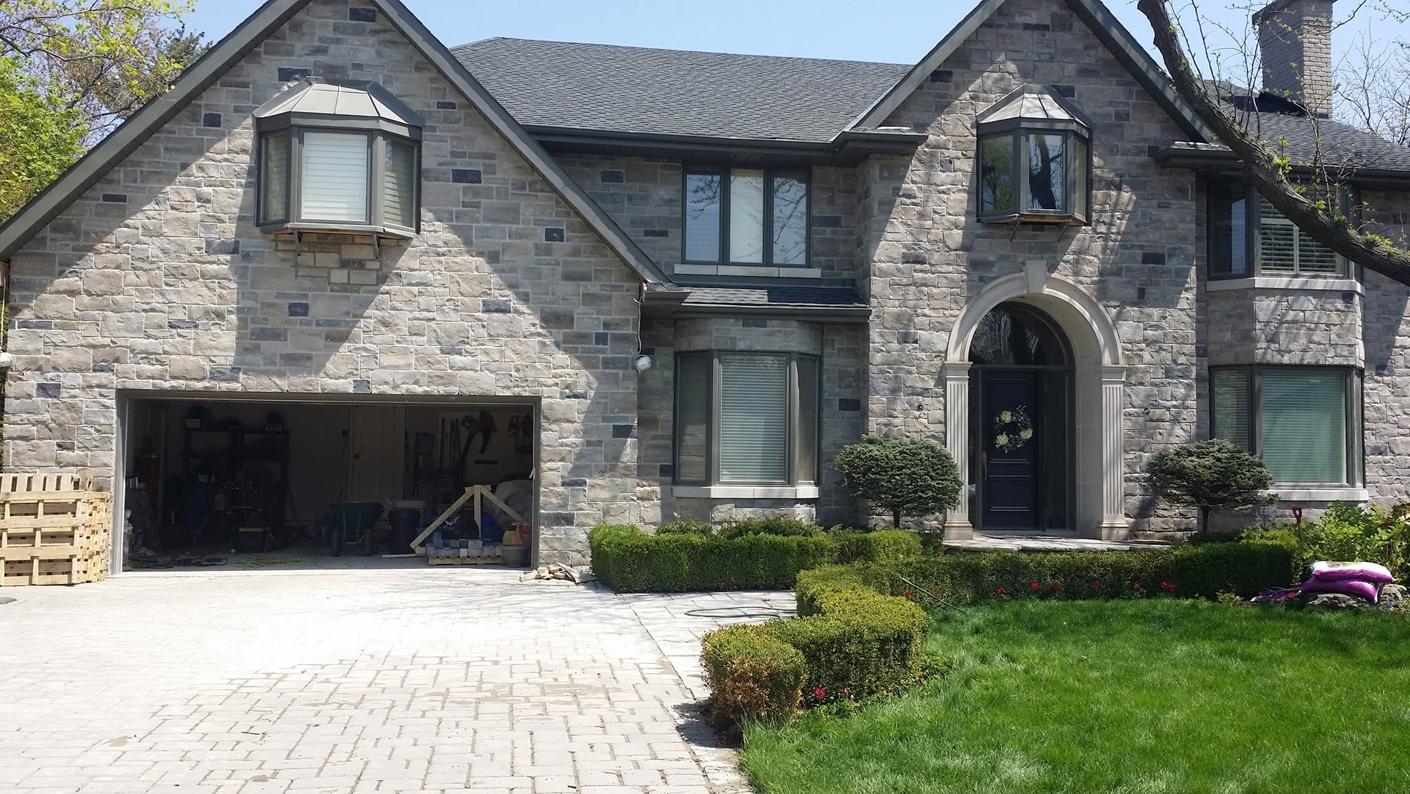After view of brick-to-stone exterior transformation with new stone facade