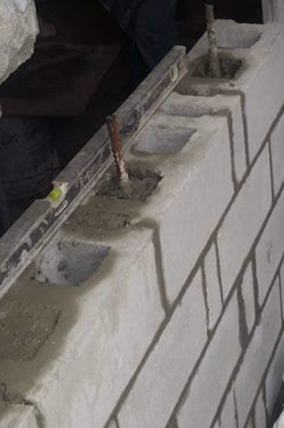 Brickwork in progress with concrete block wall alignment and fresh mortar