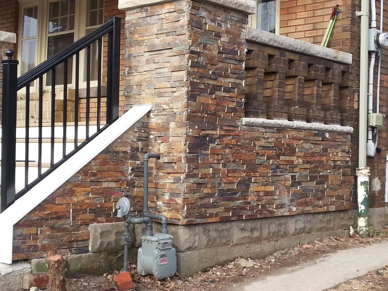 Custom stone porch renovation with layered stonework and repaired porch wall