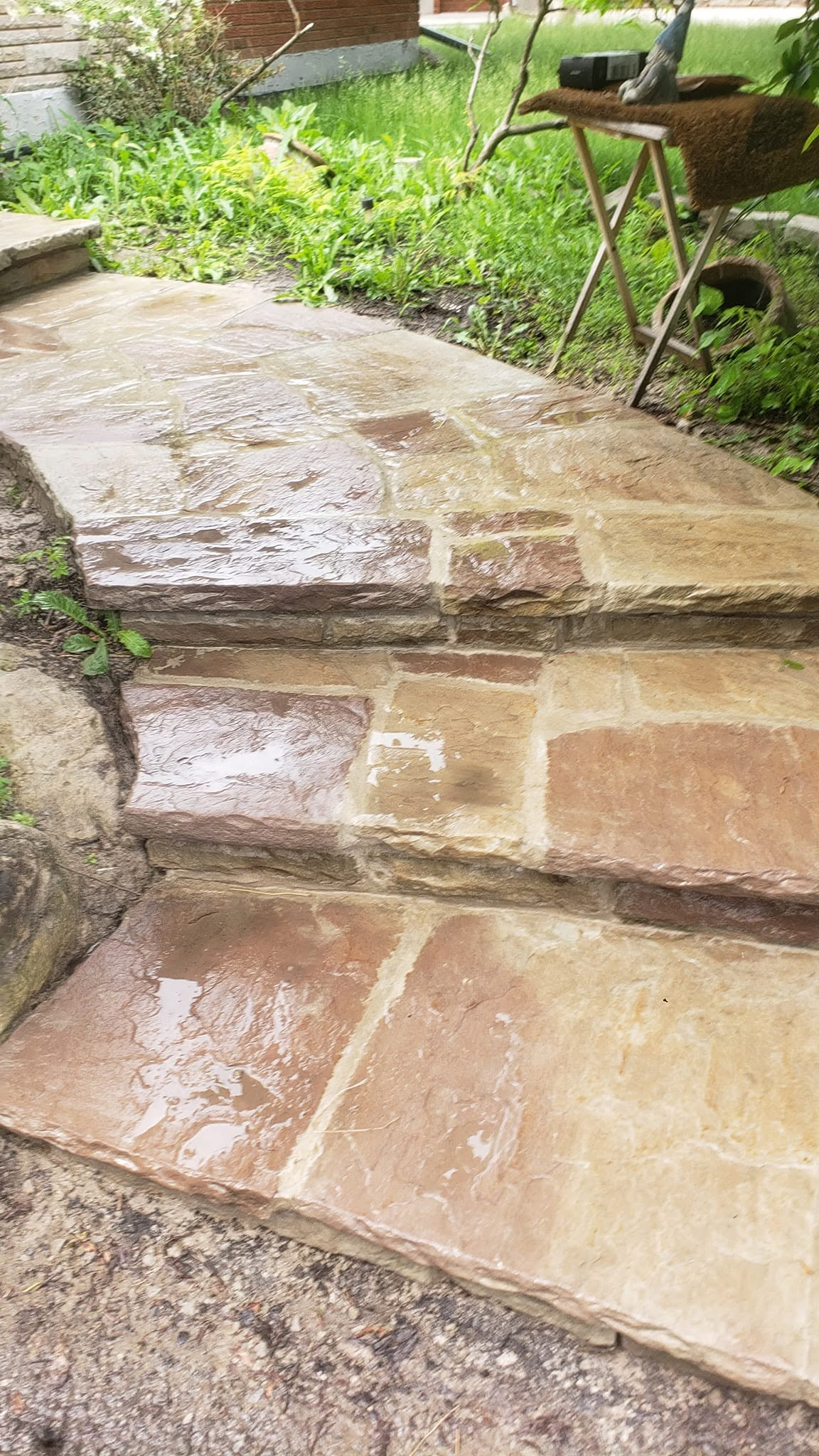 Flagstone walkway and steps repair with wet stone surface and renewed mortar joints